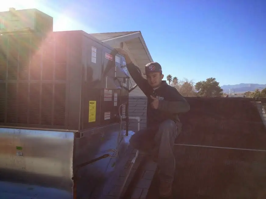 HVAC technician performing Heat Pump Repair on a rooftop unit in Beardstown