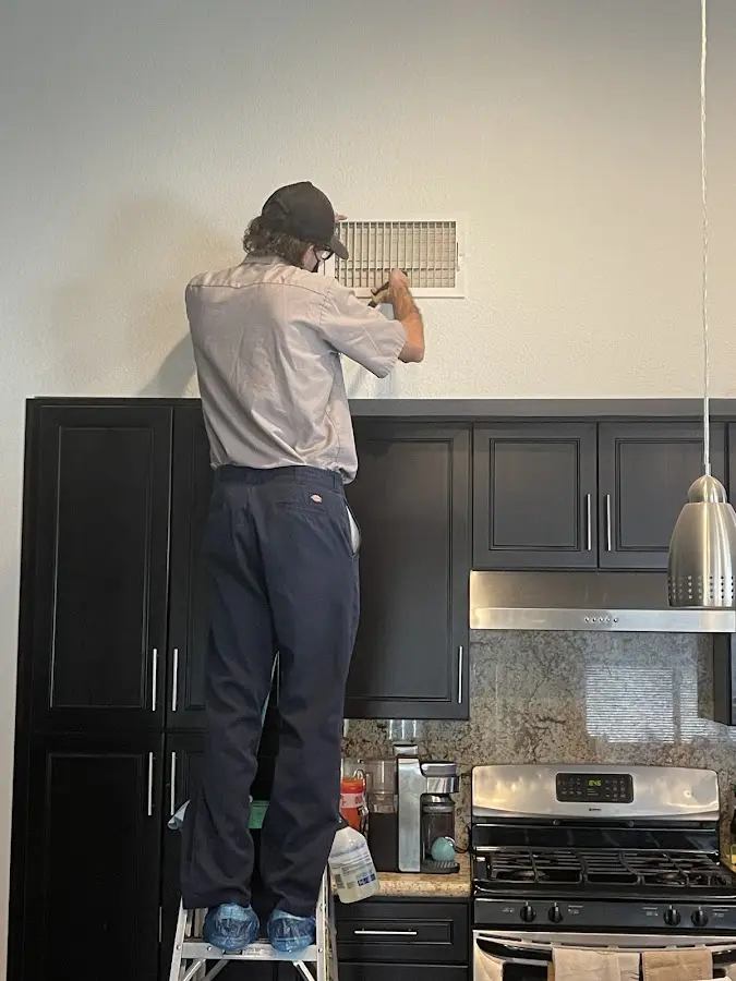 Technician inspecting an air vent during HVAC service in Beardstown
